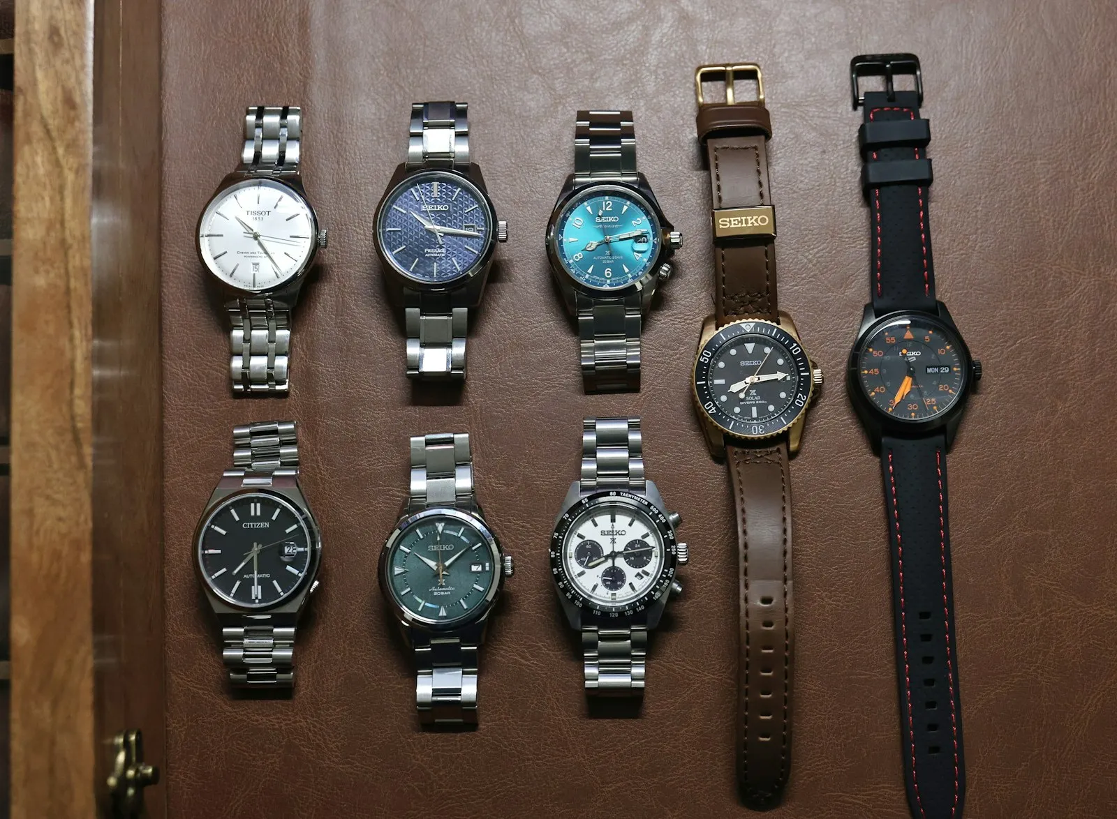 Une dizaine de montres automatiques alignées sur un présentoir en bois